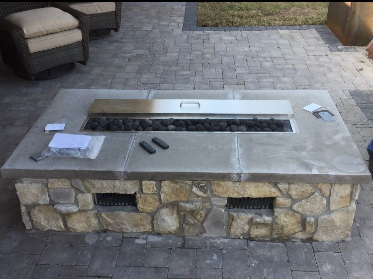 A fire pit is being built on a brick patio
