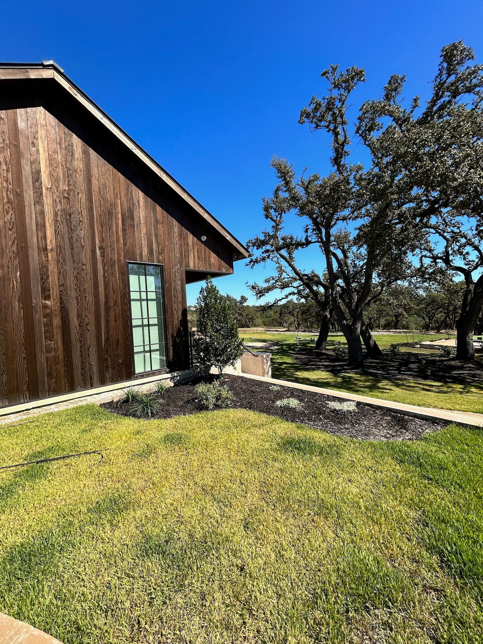 A wooden house with a lush green lawn in front of it.