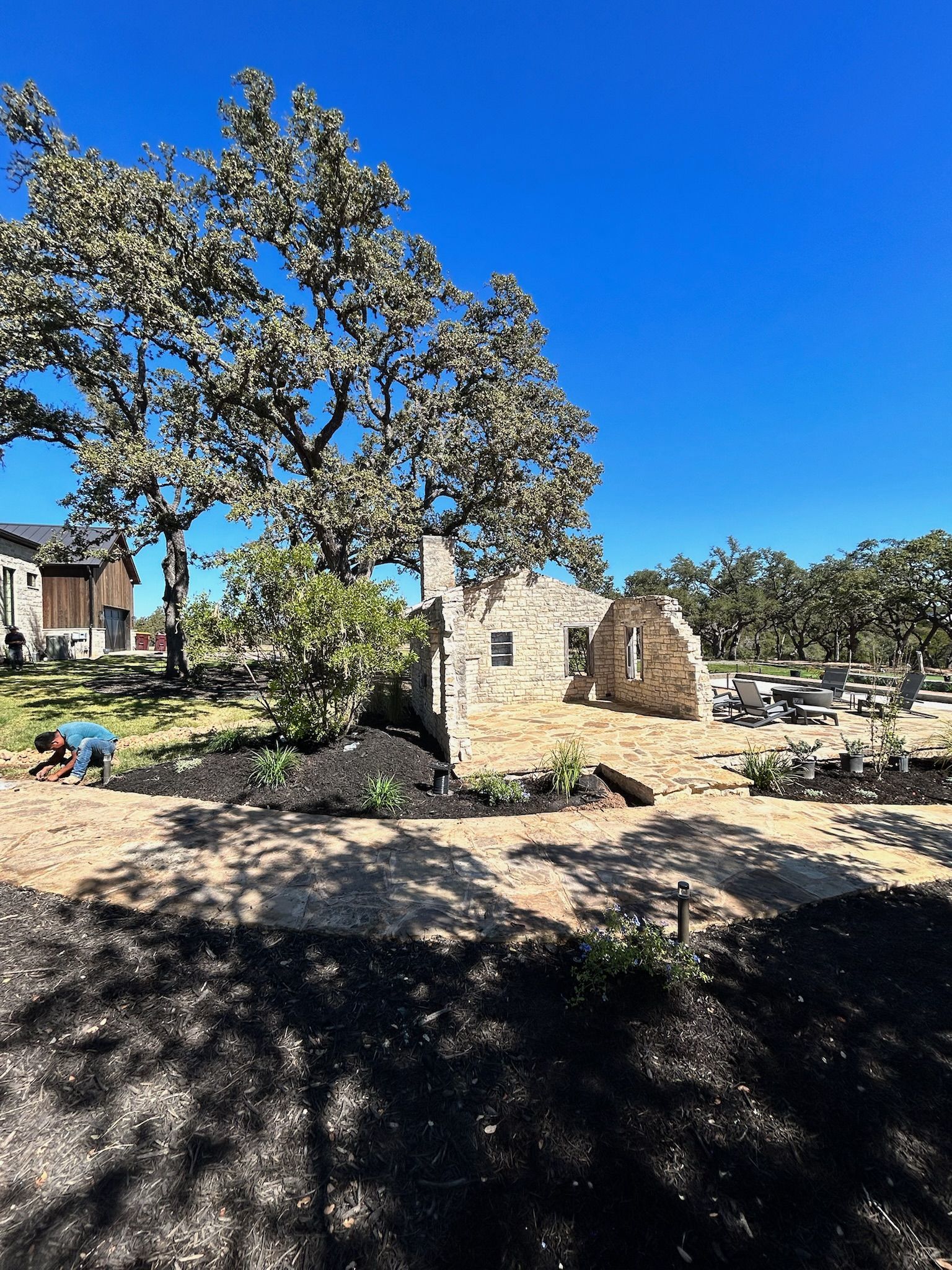 A man is working in the dirt in front of a house.