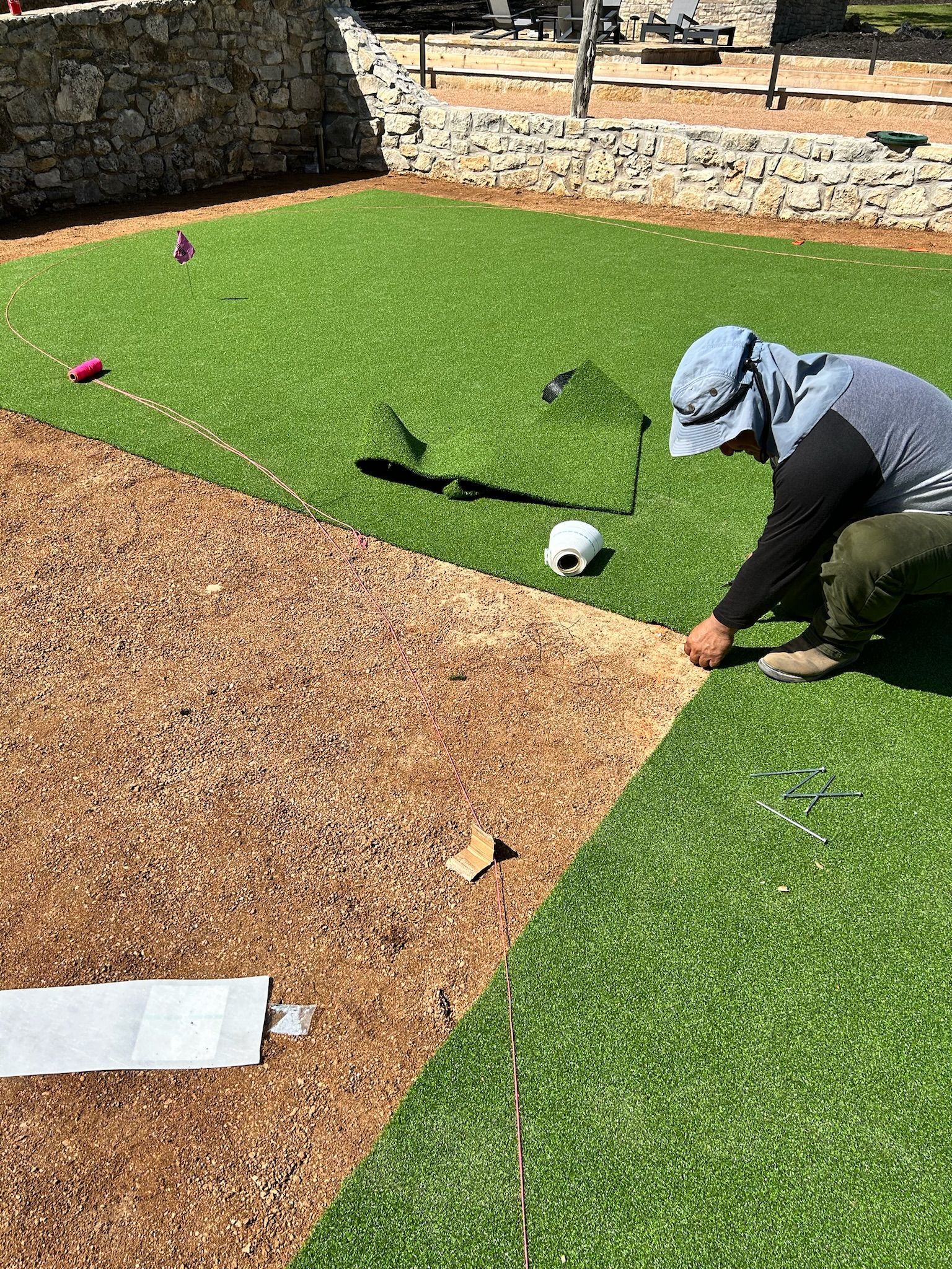 A man is kneeling down on a baseball field.