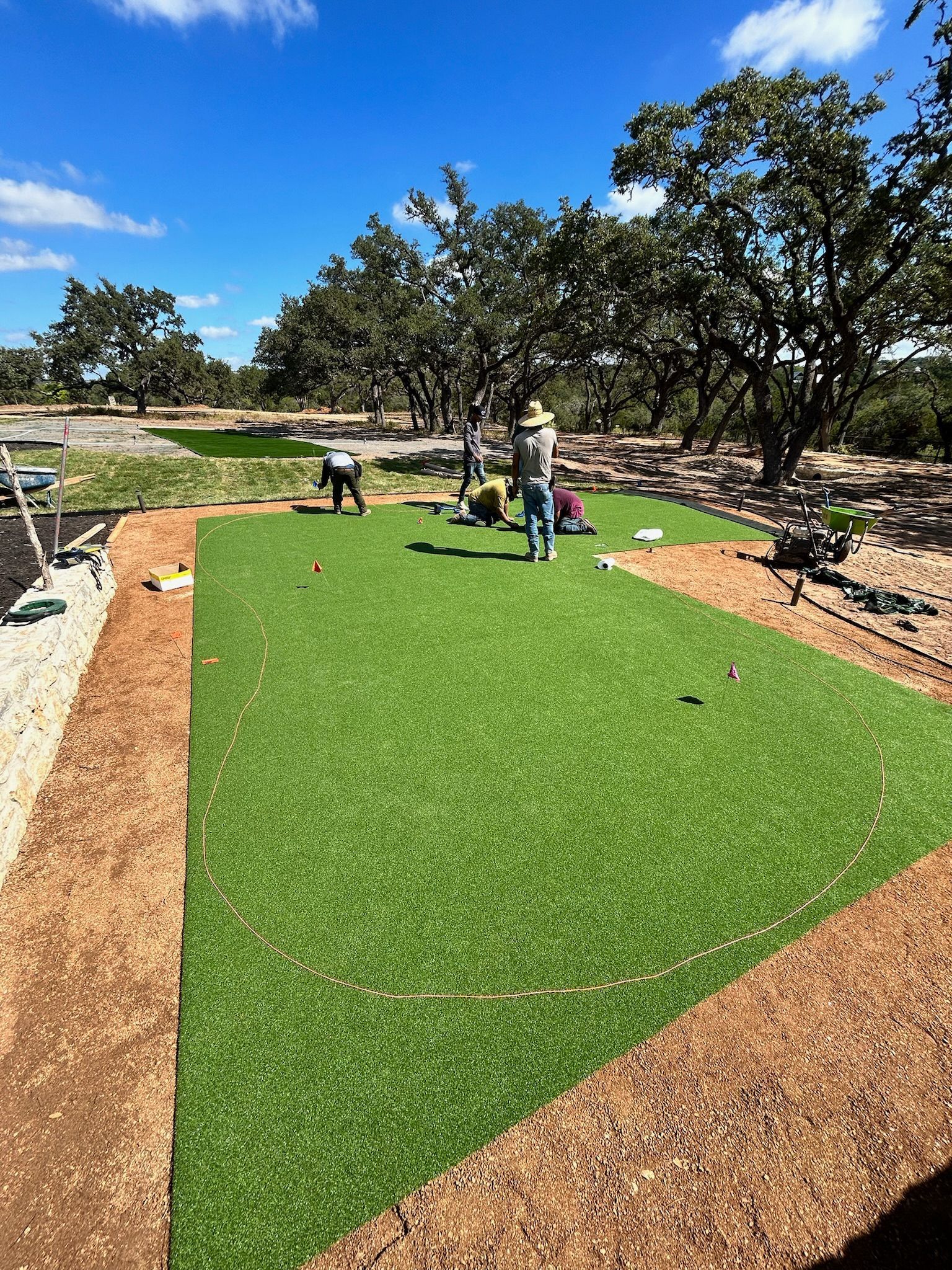 A group of people are working on a lush green lawn.