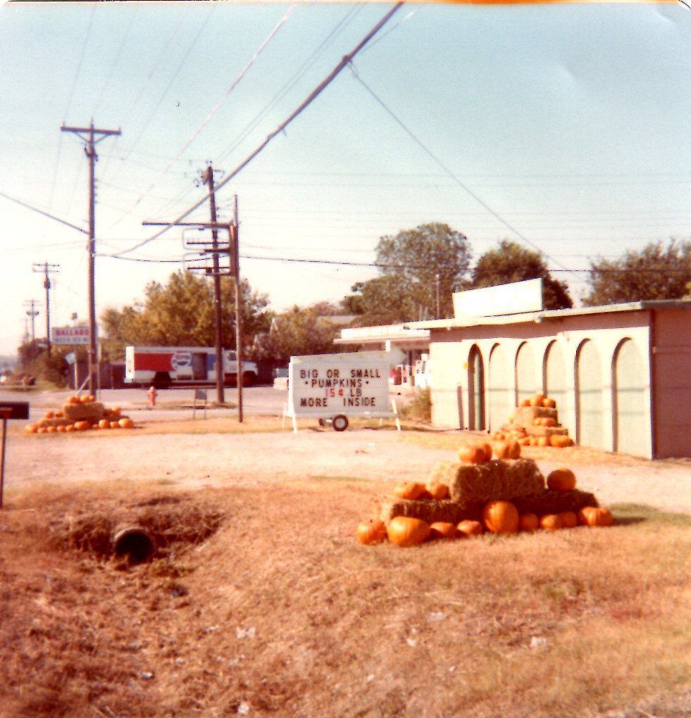 A bunch of pumpkins are sitting in front of a building