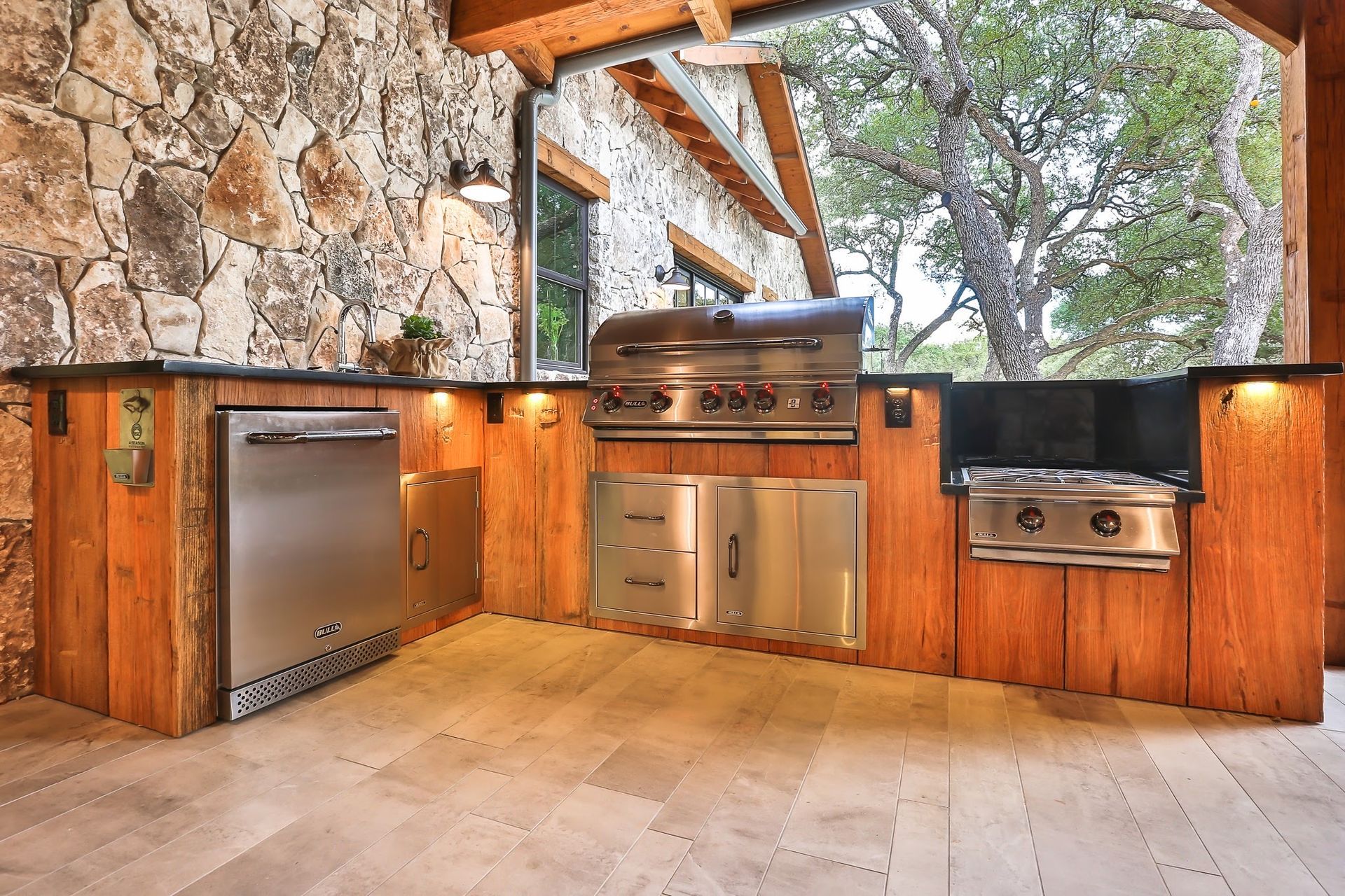 An outdoor kitchen with a grill and a dishwasher