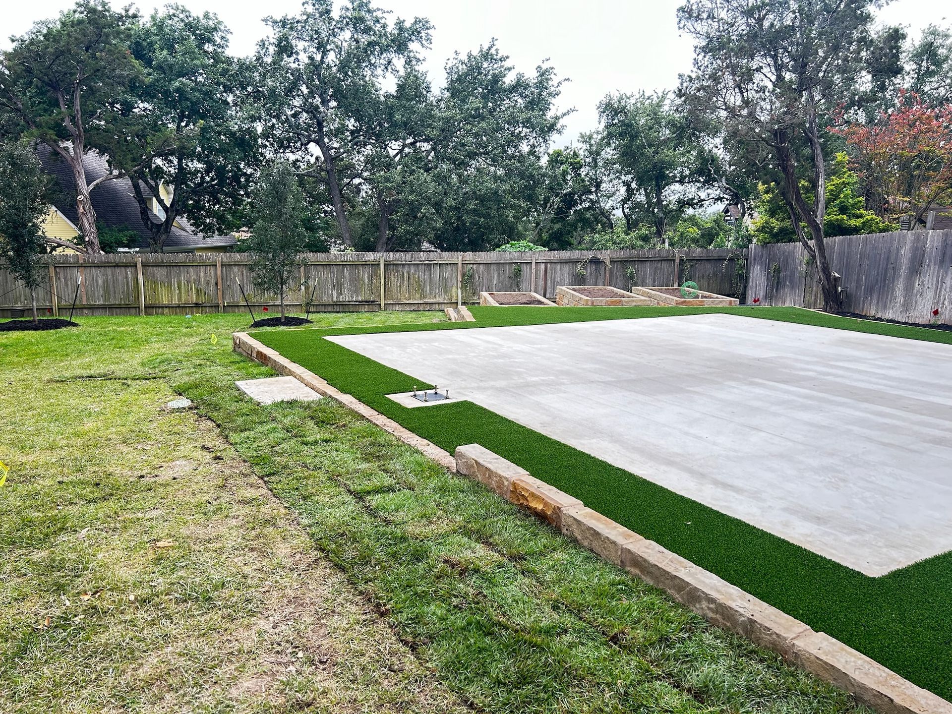 There is a concrete slab in the middle of the backyard.