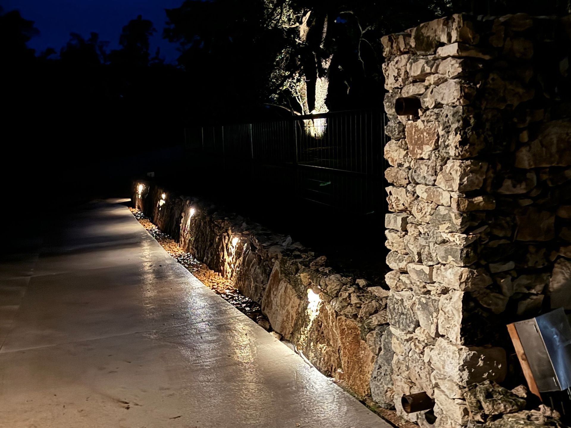 A stone wall with lights on it at night