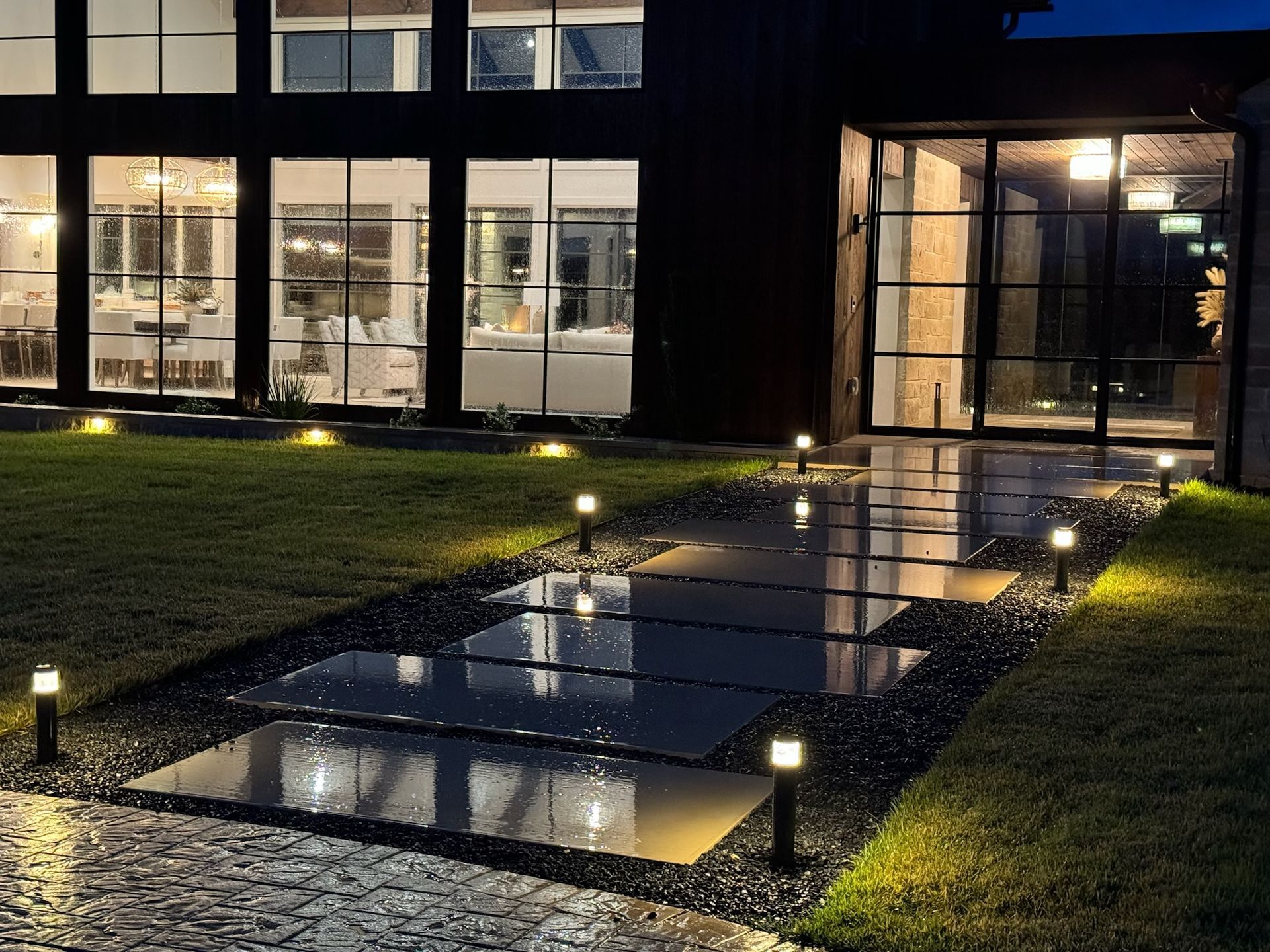 A house with a lot of windows is lit up at night