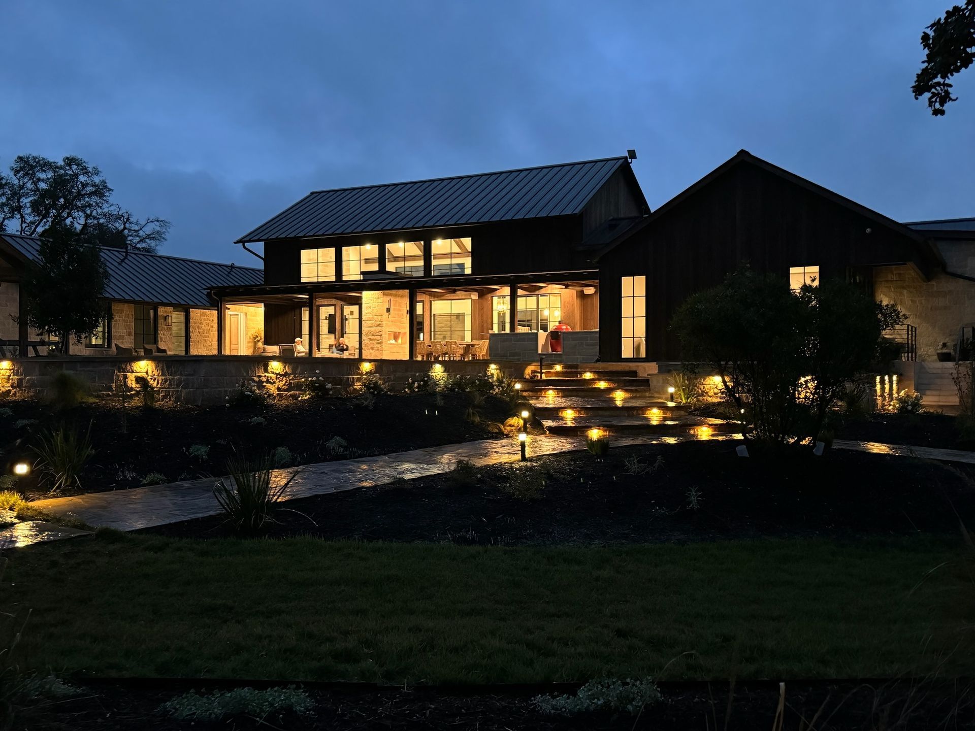 A large house with a lot of windows is lit up at night