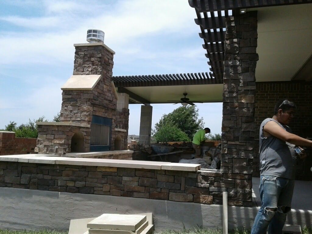 A man standing in front of a stone fireplace
