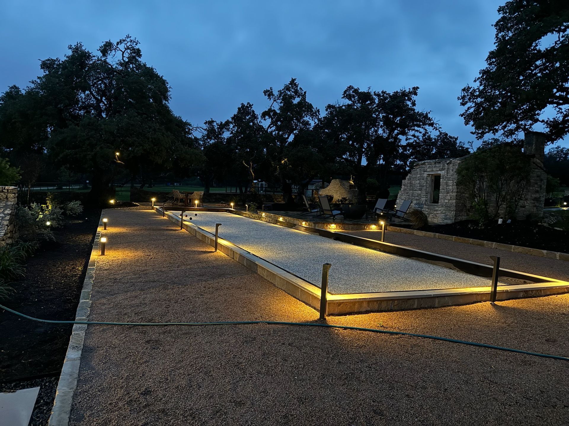 A gravel path is lit up at night with trees in the background.