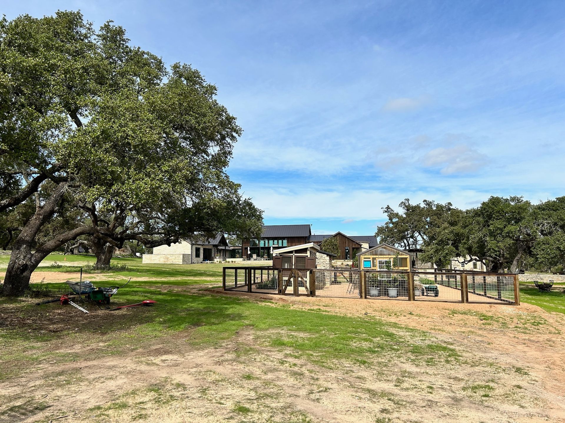 There is a playground in the middle of a field with trees in the background.