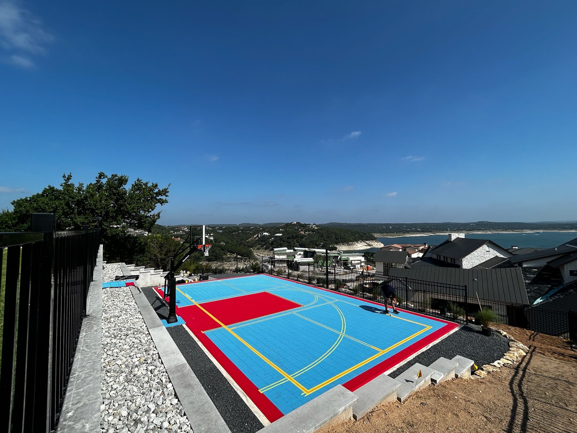 A blue and red basketball court is sitting on top of a hill.