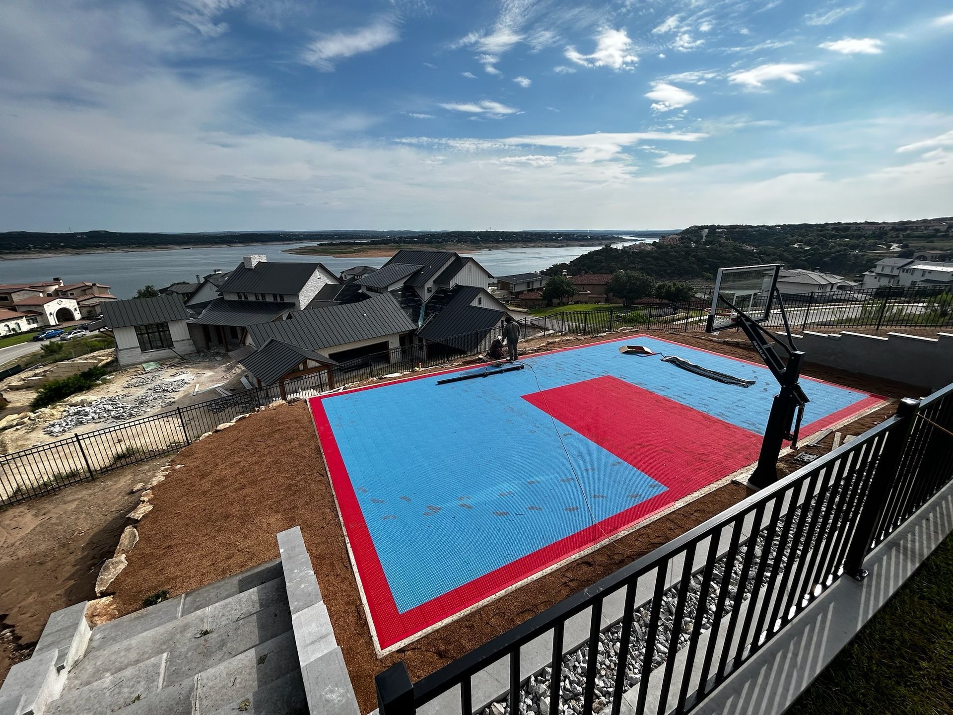 A blue and red karate mat is sitting on top of a hill next to a lake.
