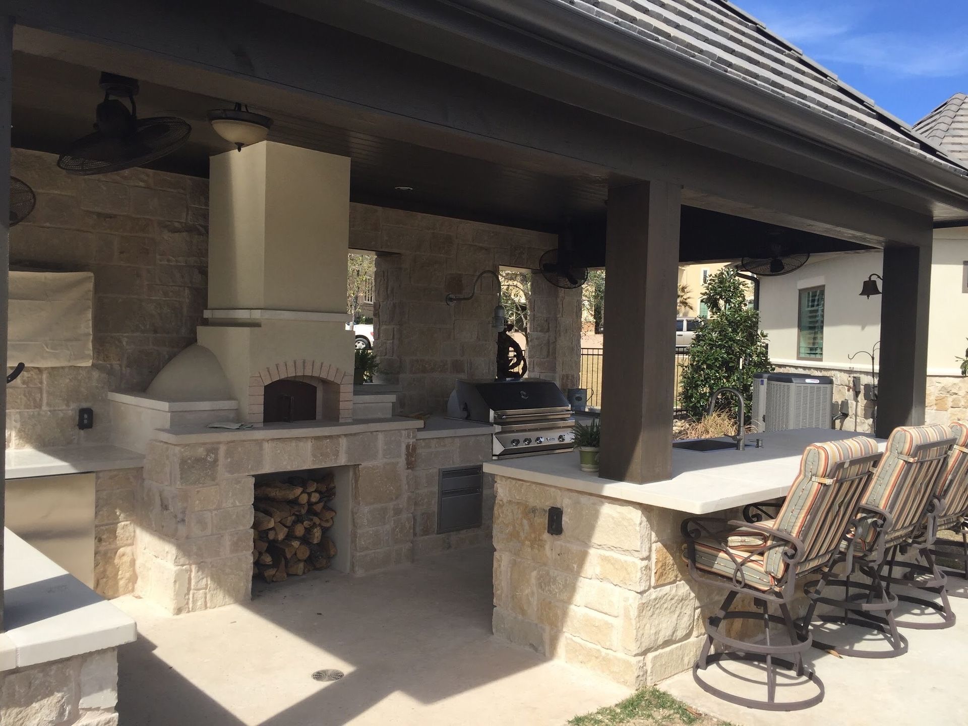 A patio with a pizza oven and a table and chairs