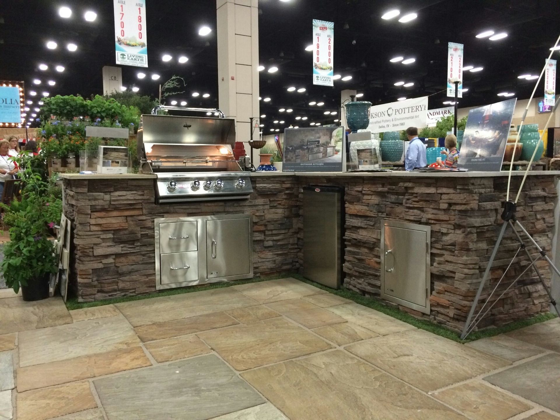 A kitchen with a stainless steel grill and a stone counter top