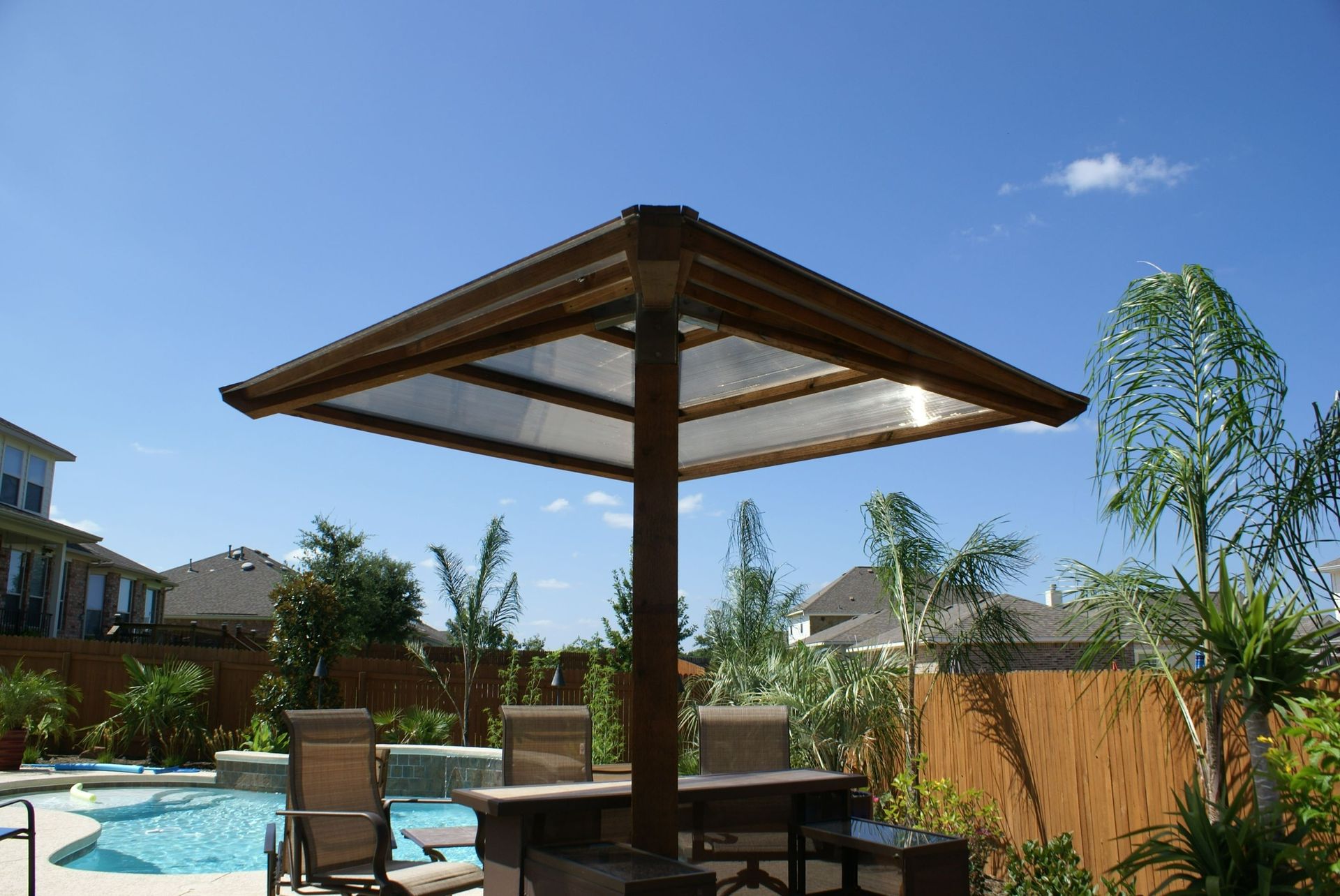 A gazebo with a table and chairs in front of a pool