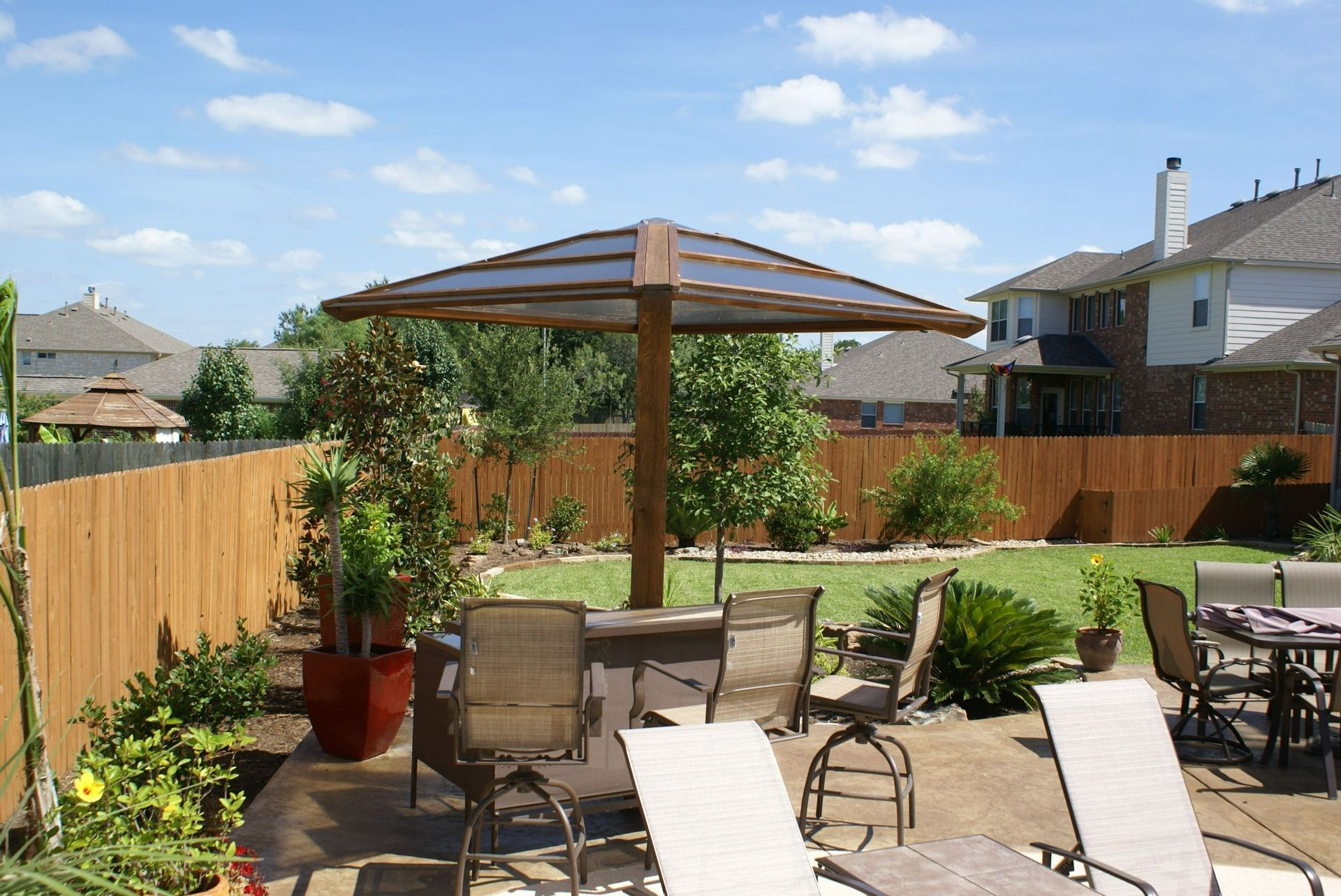 A backyard with a table and chairs under an umbrella