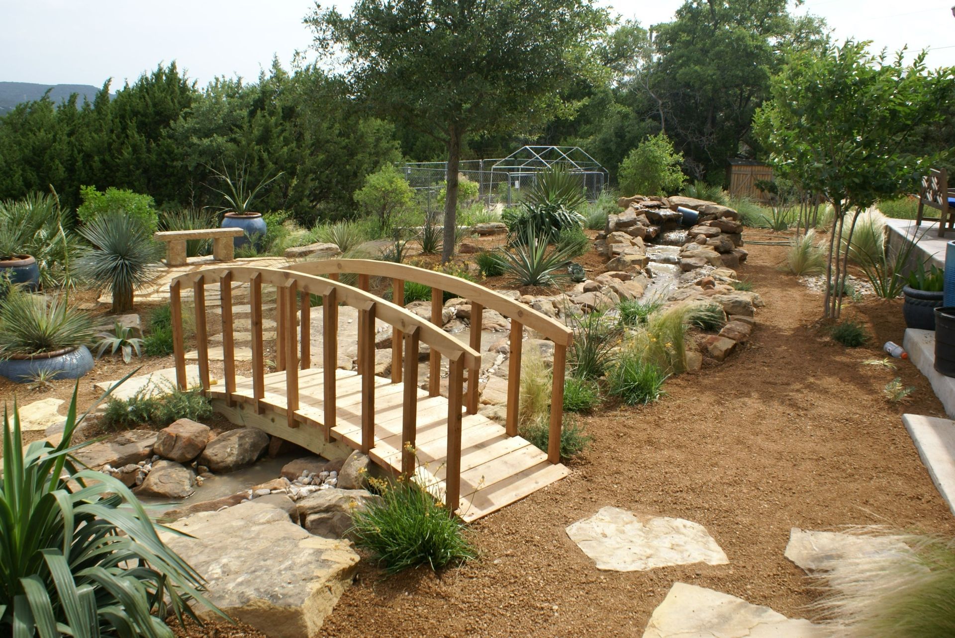 A wooden bridge over a stream in a garden