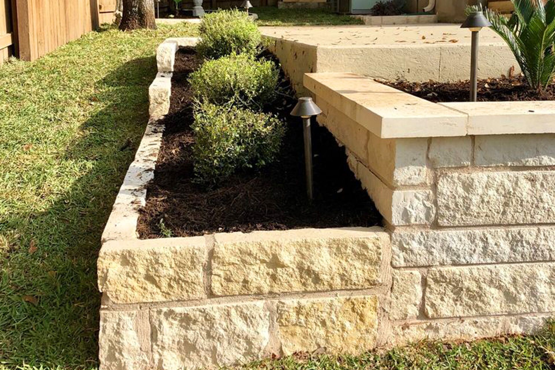 A brick wall with a planter in the middle of it.