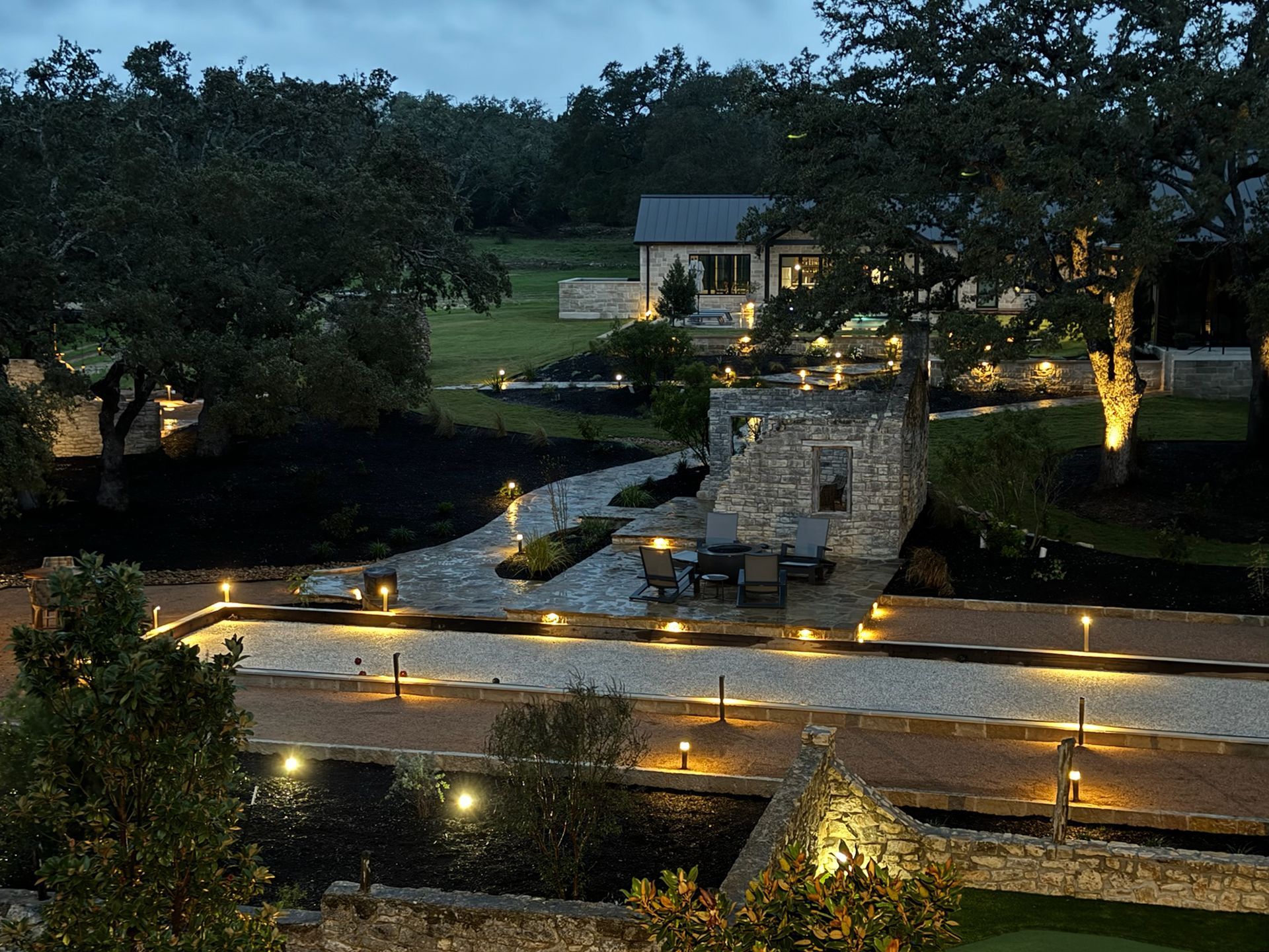 An aerial view of a backyard with a house in the background