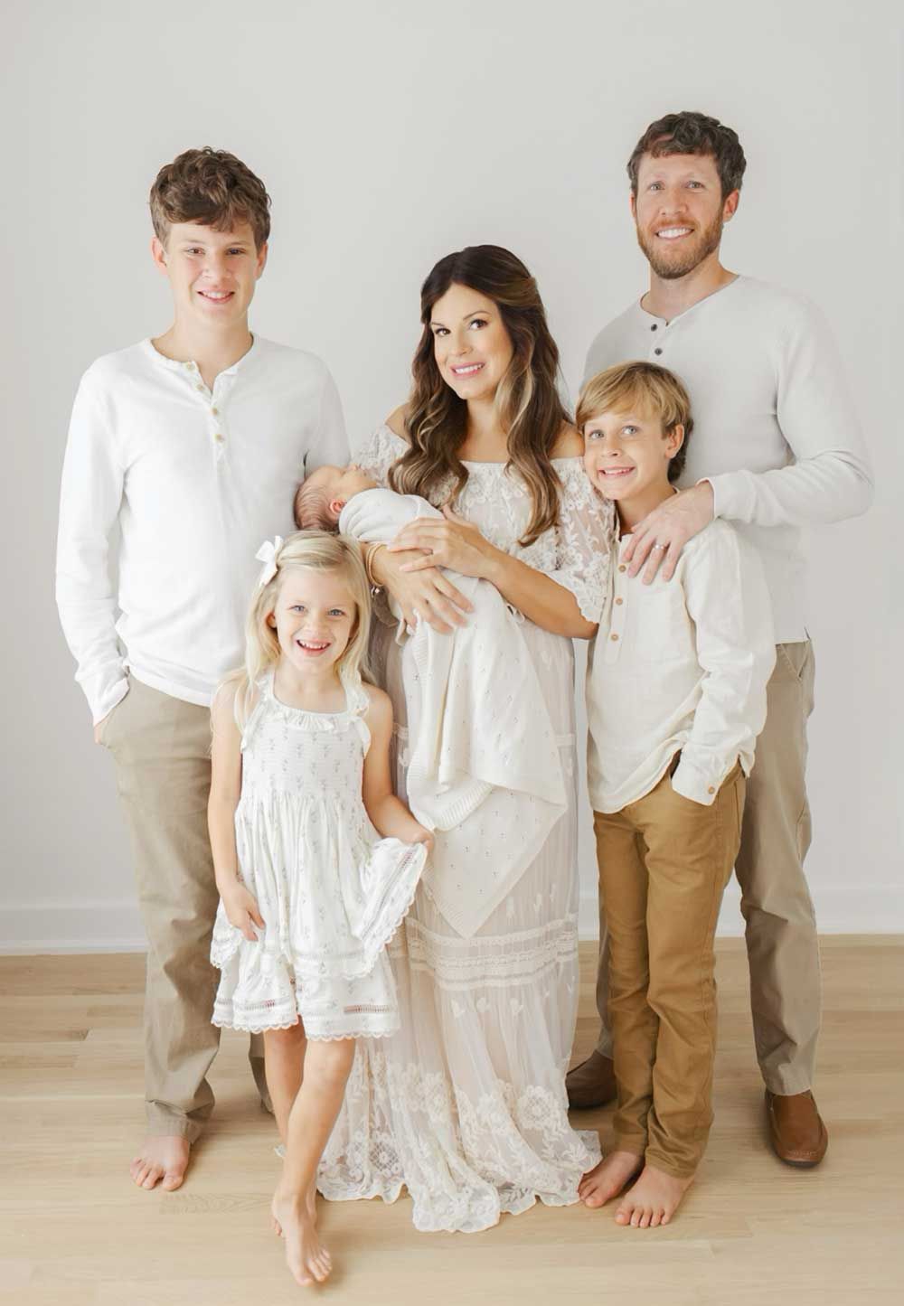 A family is posing for a picture with a newborn baby.