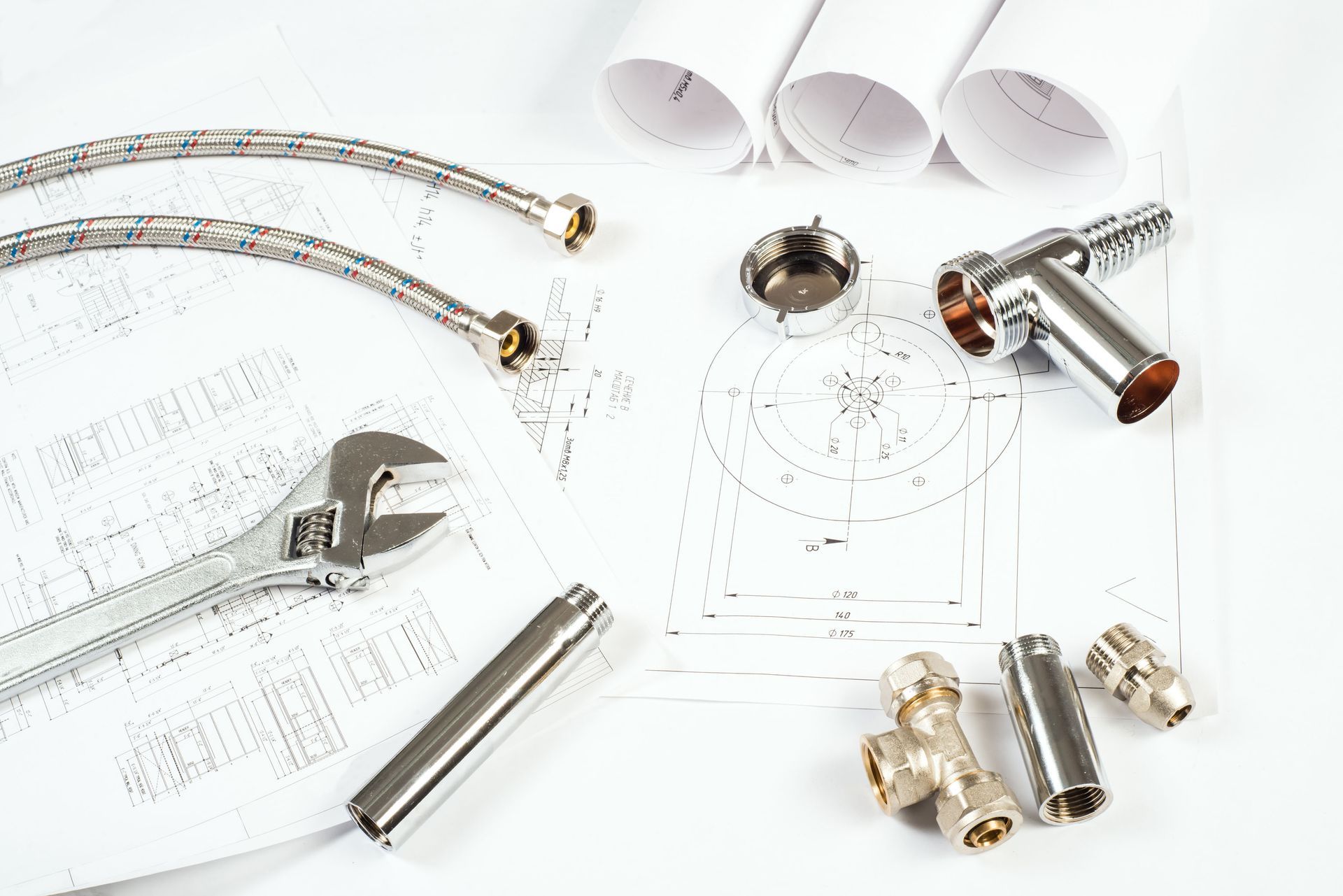 A wrench is sitting on top of a drawing of pipes.