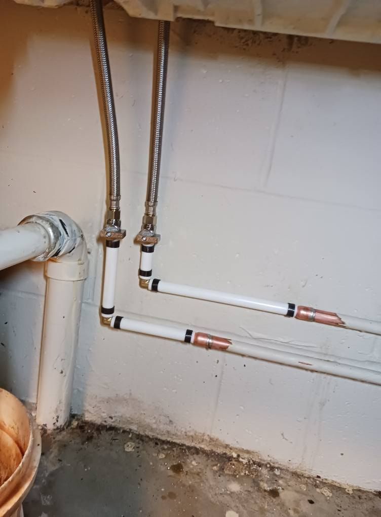 A close up of a bathroom sink with pipes coming out of it.