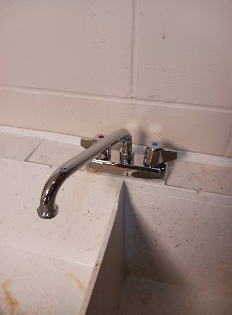 A close up of a faucet on a sink in a bathroom.