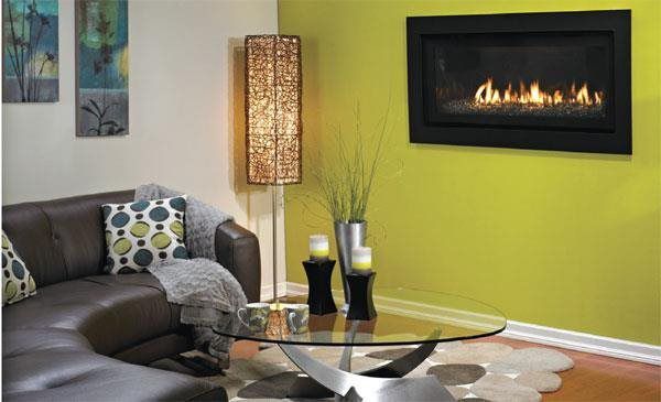 A living room with a couch and a fireplace on the wall.