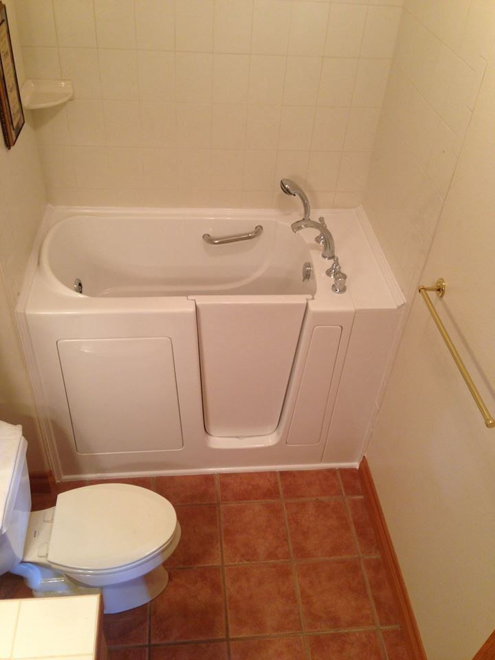 A bathroom with a walk in tub and a toilet