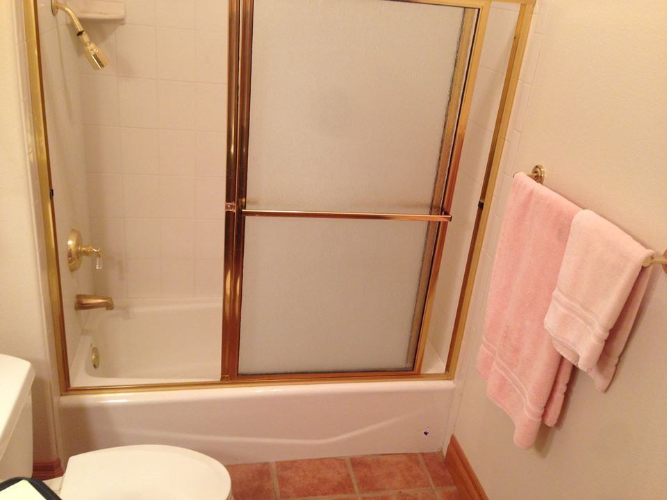 A bathroom with a toilet , bathtub and shower.