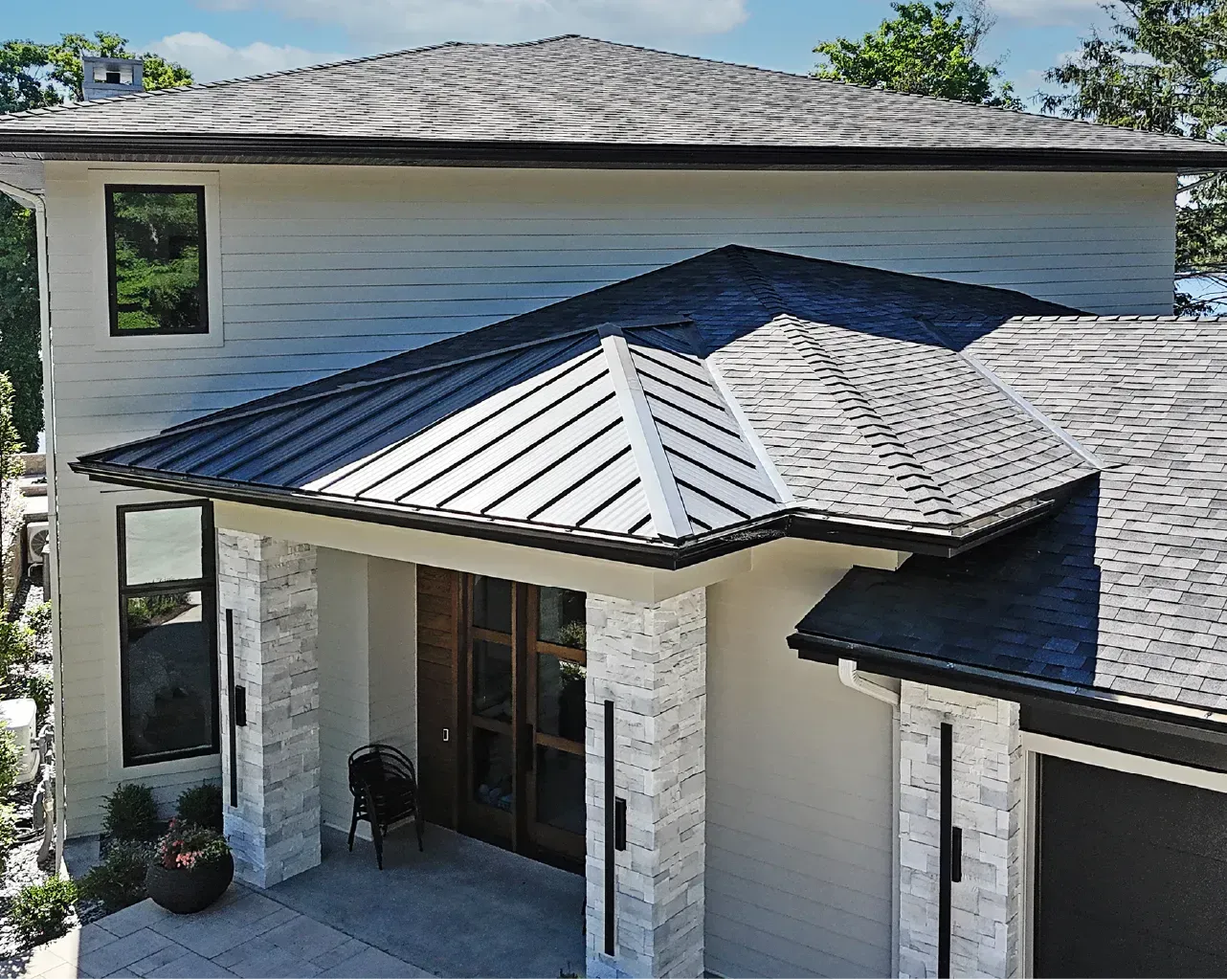 An aerial view of a white house with a black roof