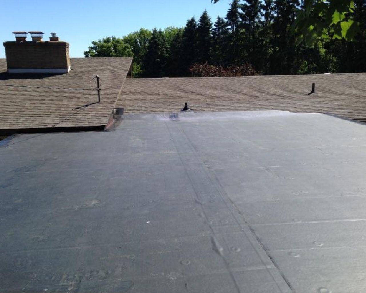 A black roof with a chimney on top of it