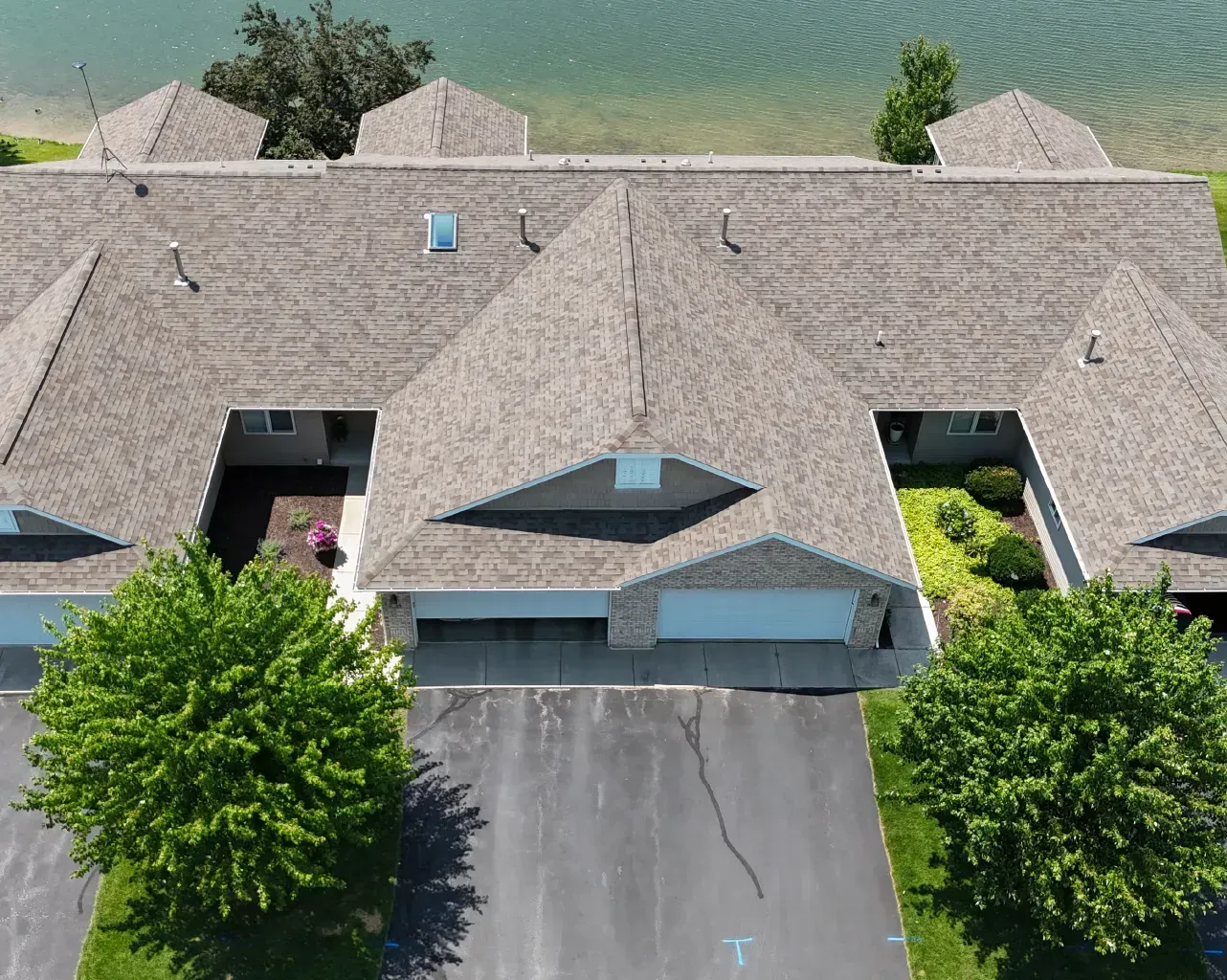 An aerial view of a house with a lake in the background