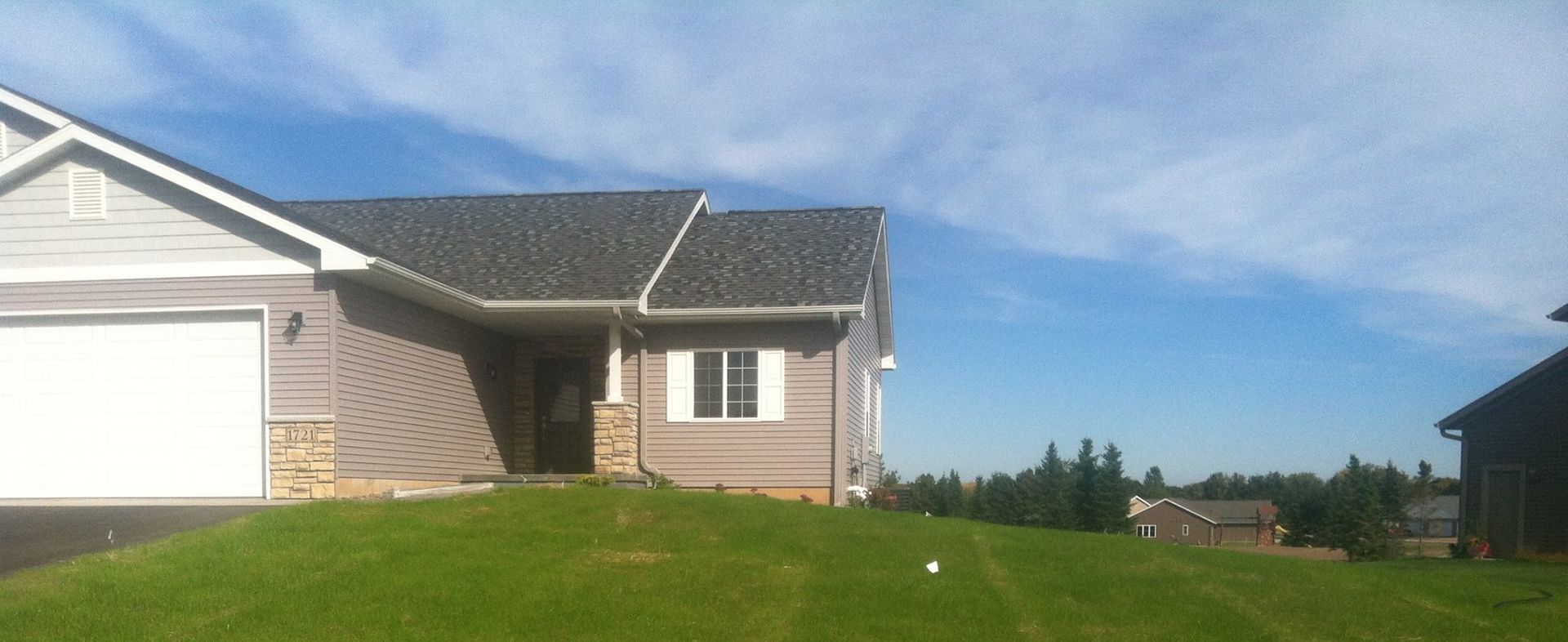 A house with a garage and a lawn in front of it