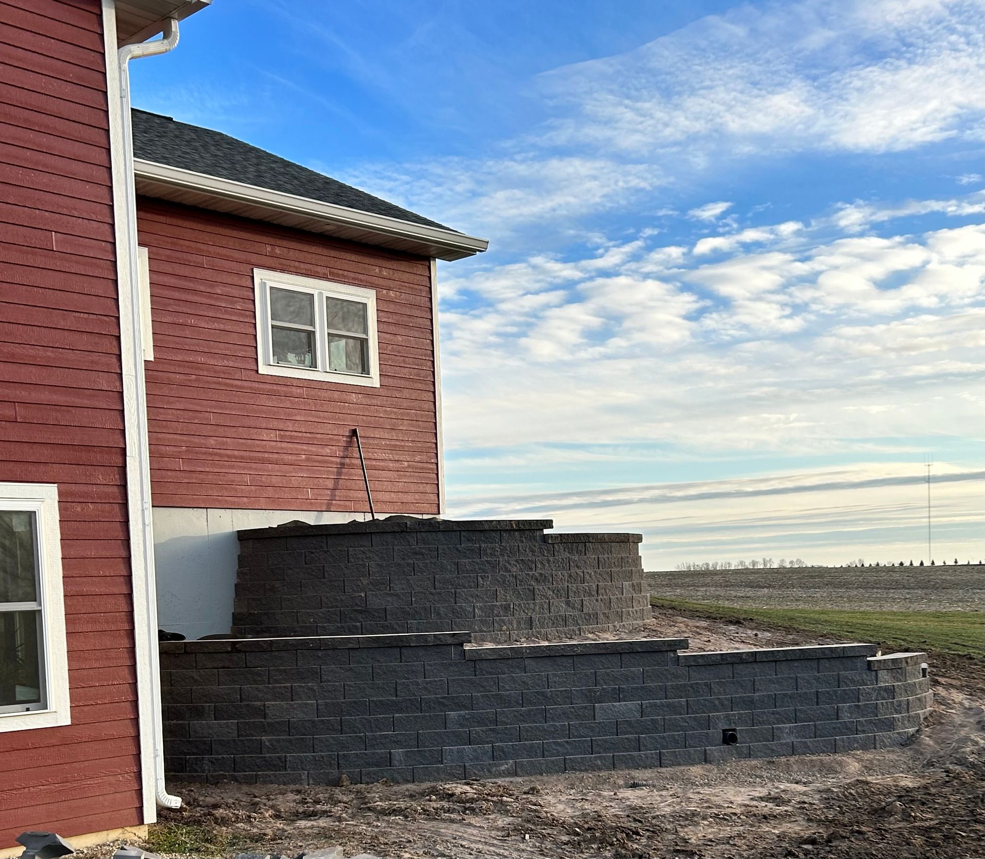 A red brick house with a brick wall in front of it