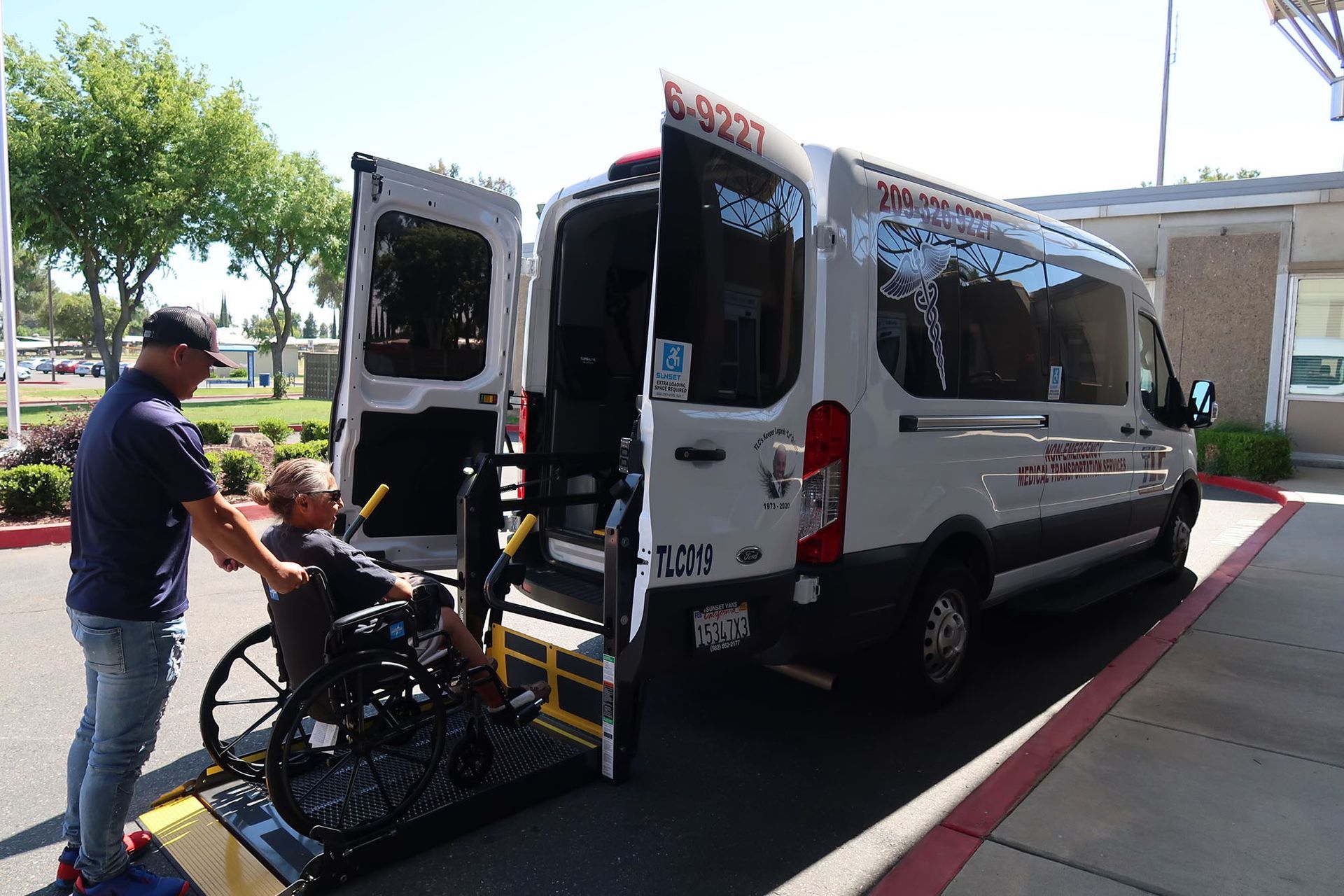 A man is helping a disabled man in a wheelchair into a van