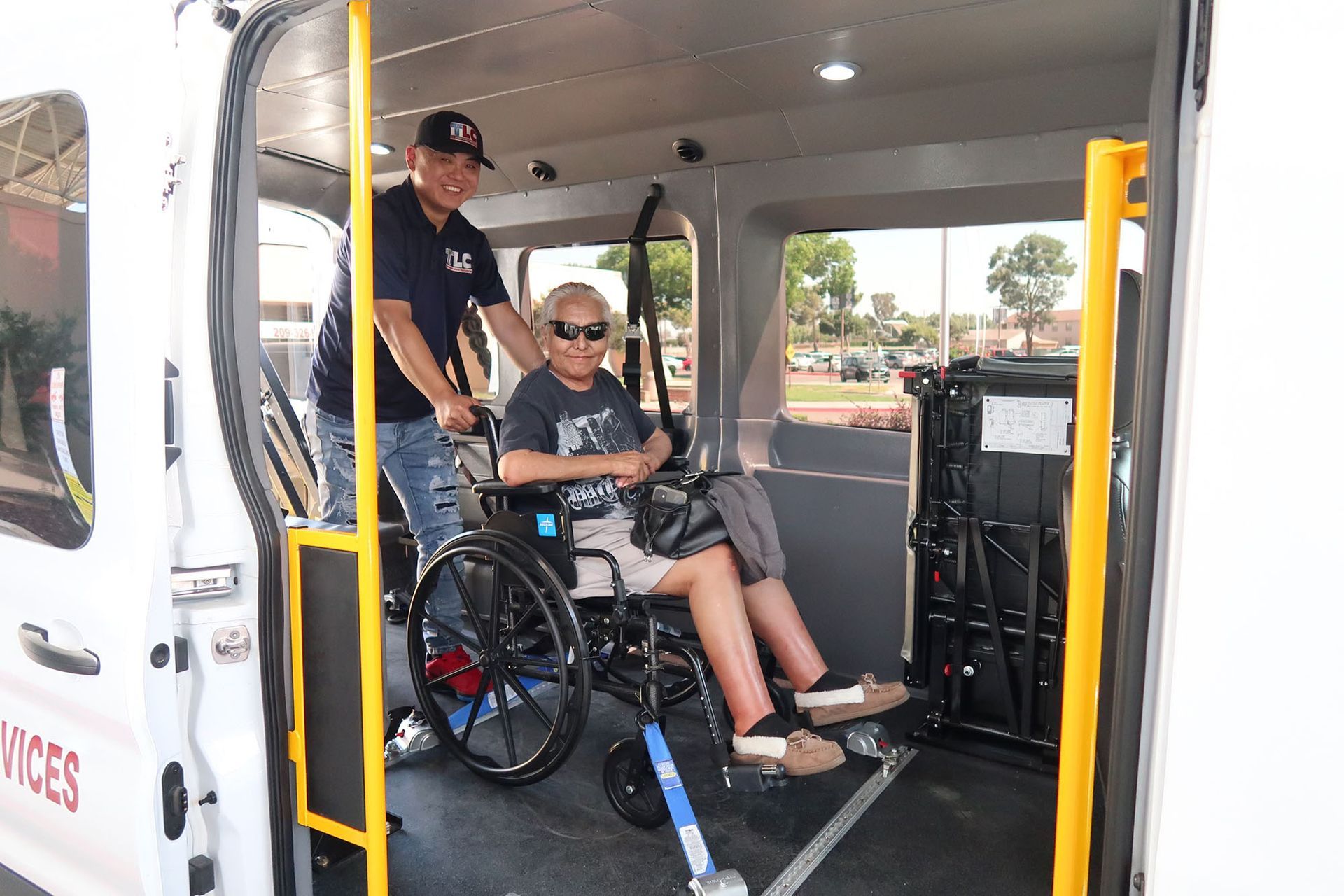 A man is pushing a man in a wheelchair inside a van