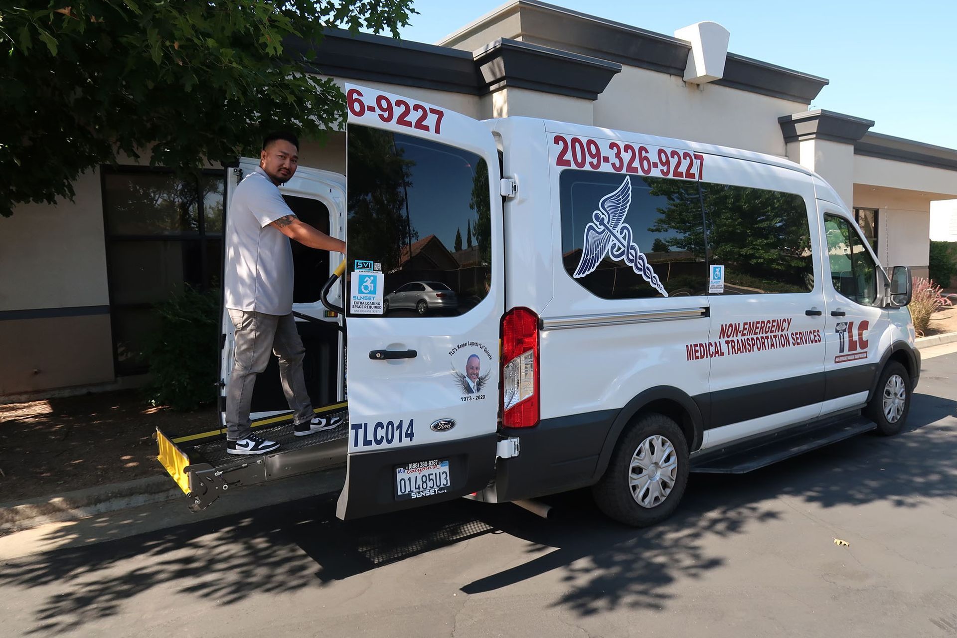A man is helping someone get inside a handicapped van