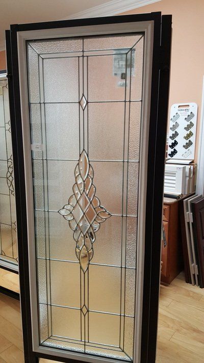 A decorative glass door with a black frame and ornate glass panels.