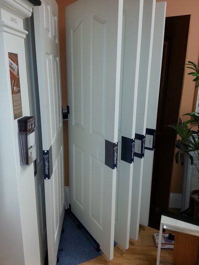 White interior doors on display, showcasing door styles, in a showroom setting.