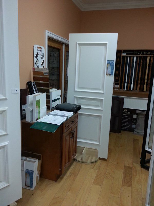 Interior room displaying white panel door samples and wood flooring.