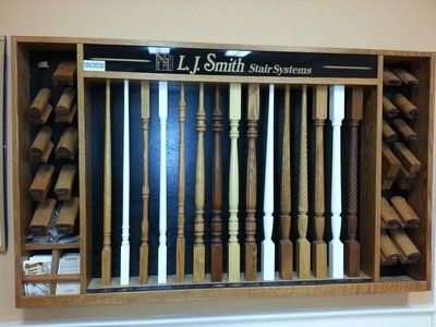 Stair baluster display by L.J. Smith. Various wood styles and finishes are shown in a store display.