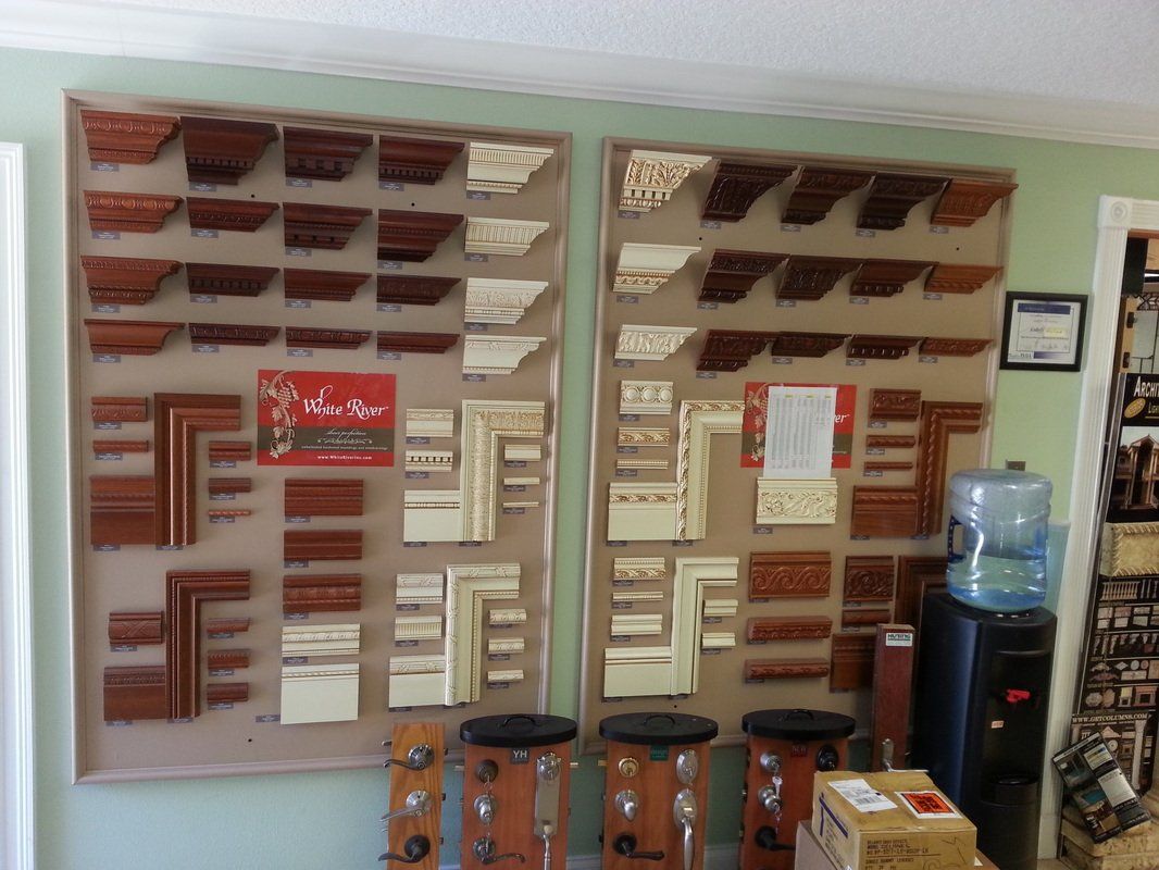 Display of wood molding samples, various styles and colors, on boards in a store.