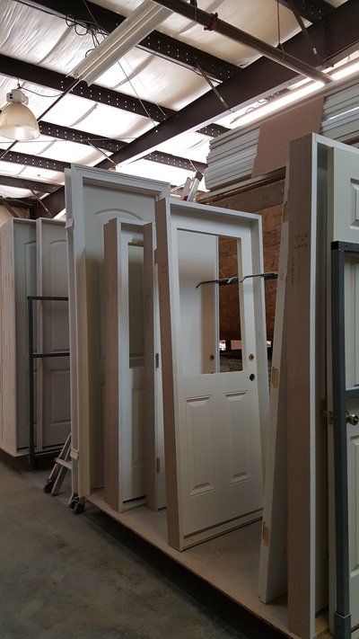 White doors and frames in a warehouse, ready for installation.