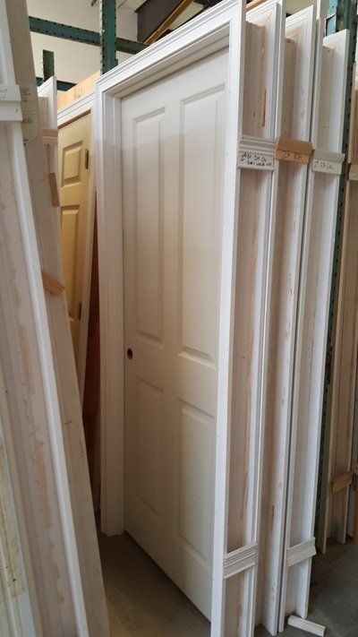 White interior door and trim, standing with others in a warehouse.