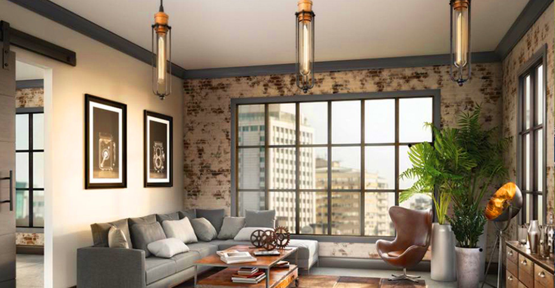 Industrial-style living room with gray sofa, large window, exposed brick walls, pendant lights, and a leather armchair.