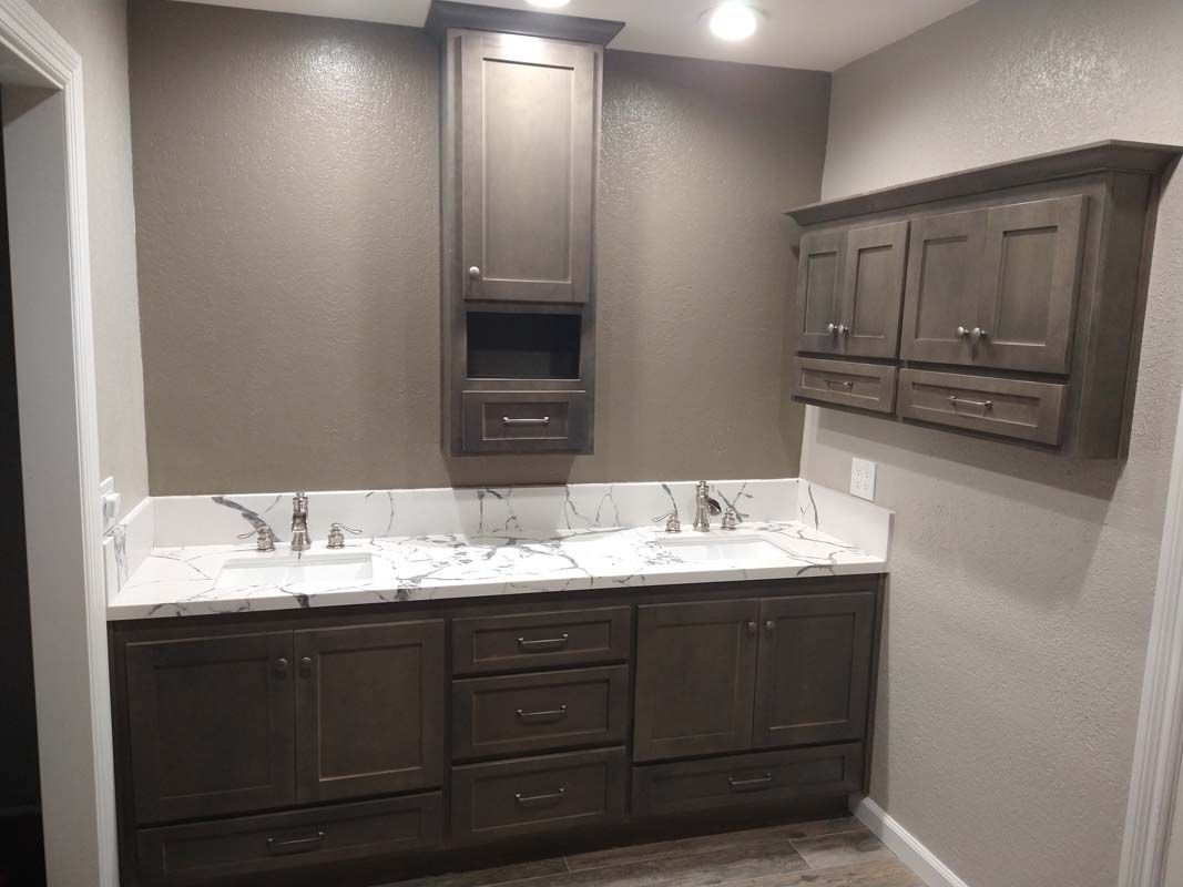 Bathroom with dark brown cabinetry, white countertop, and gray walls.