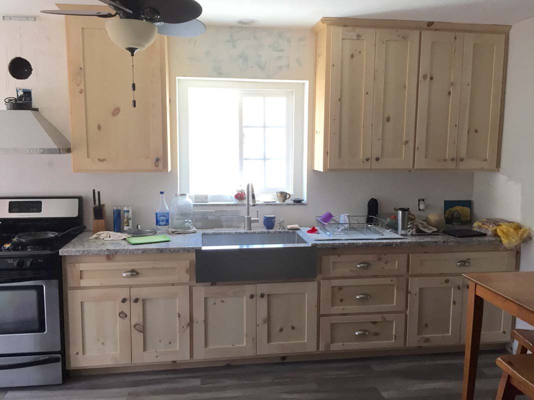 Kitchen with light wooden cabinets, stainless steel appliances, and a farmhouse sink.