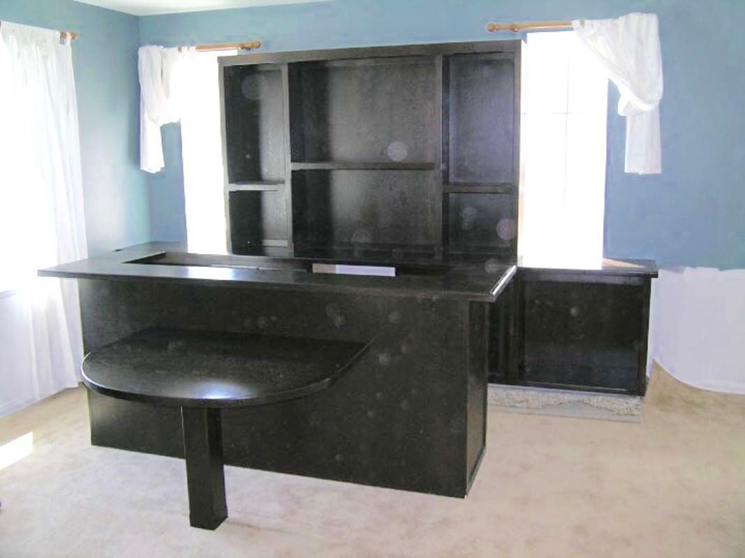 Black home bar with overhead shelving unit, partial blue wall, white curtains.