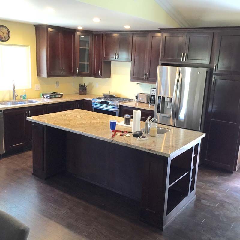 Kitchen with dark brown cabinets, light countertops, and a stainless steel refrigerator.